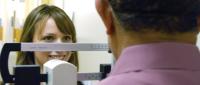 Medical student measuring patients's height with a stadiometer.